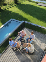 STAY Compact Bord & 4 Pallar, Mörkgrå Aluminium Fyra personer sitter på pallarna runt bordet utomhus