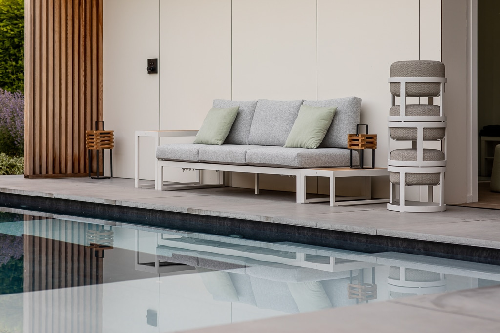 Tre pallar staplade på varandra på sidan av en pool bredvid en soffa