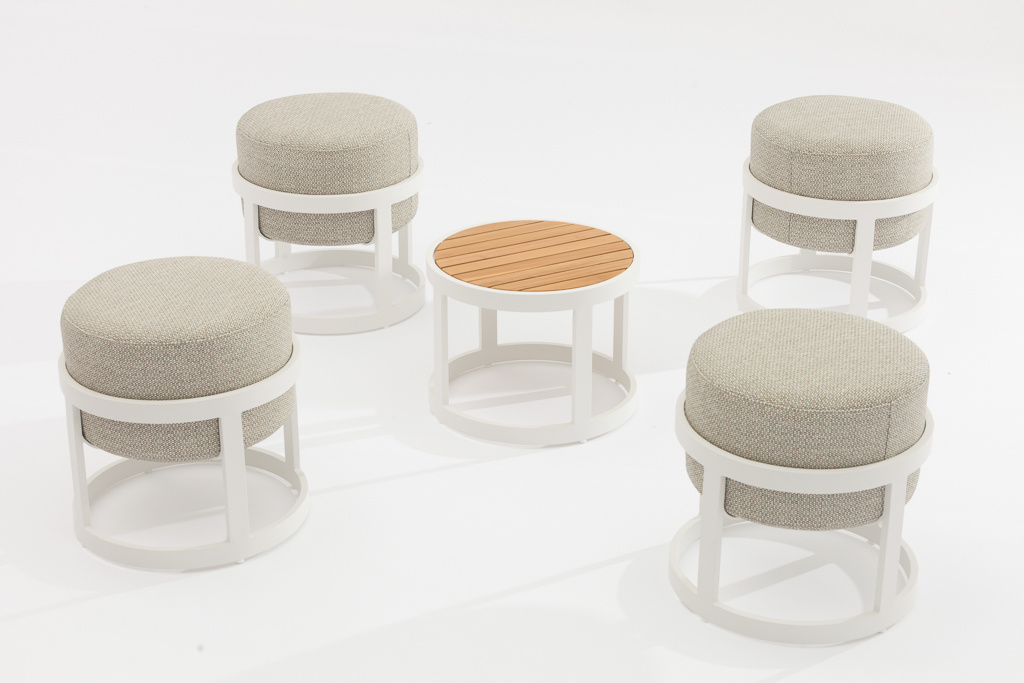 Fyra pallar och ett bord mot en ljusgrå bakgrund