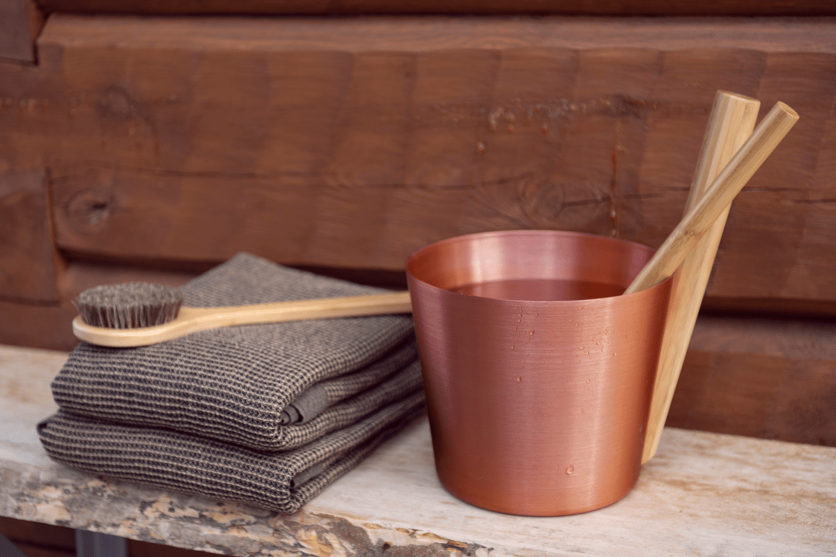 Bastuhink står på en bänk med handdukar och en borste på sidan bredvid