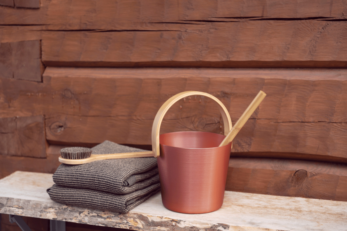 Bastuhink står på en bänk med handdukar och en borste på sidan bredvid