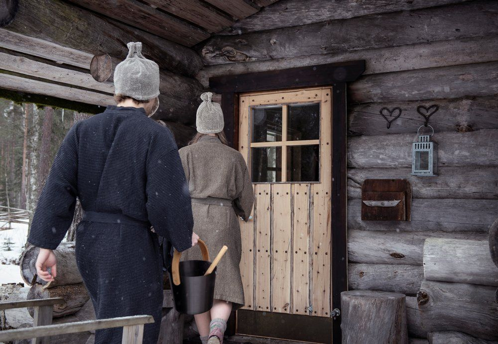 Två personer har bastumössor på sig när de går till bastun