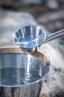 Bastuhink och Skopa i Rostfritt Stål Skopan häller vatten i en bastuhink