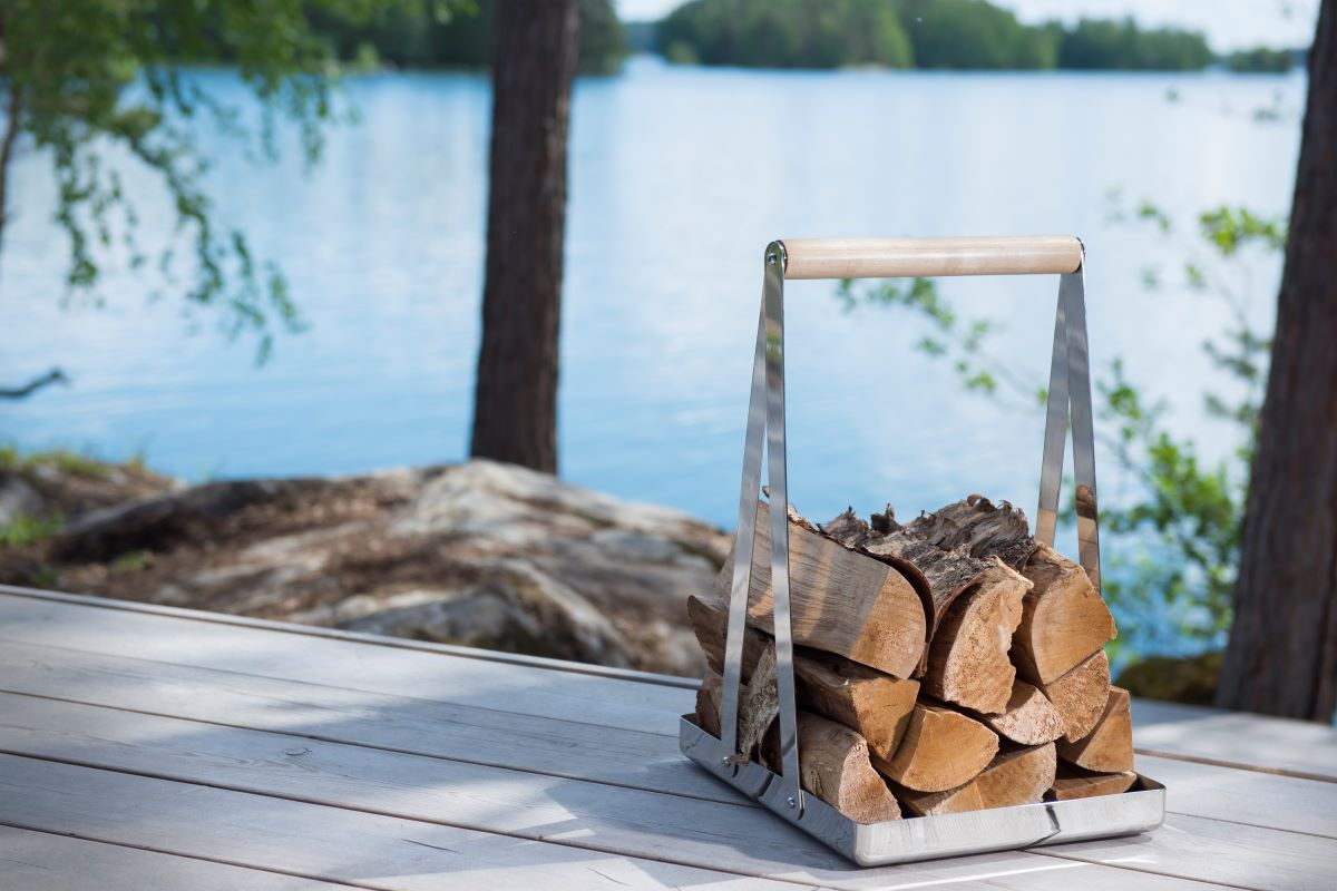 Vedkorgen på ett trädäck utomhus bredvid en sjö