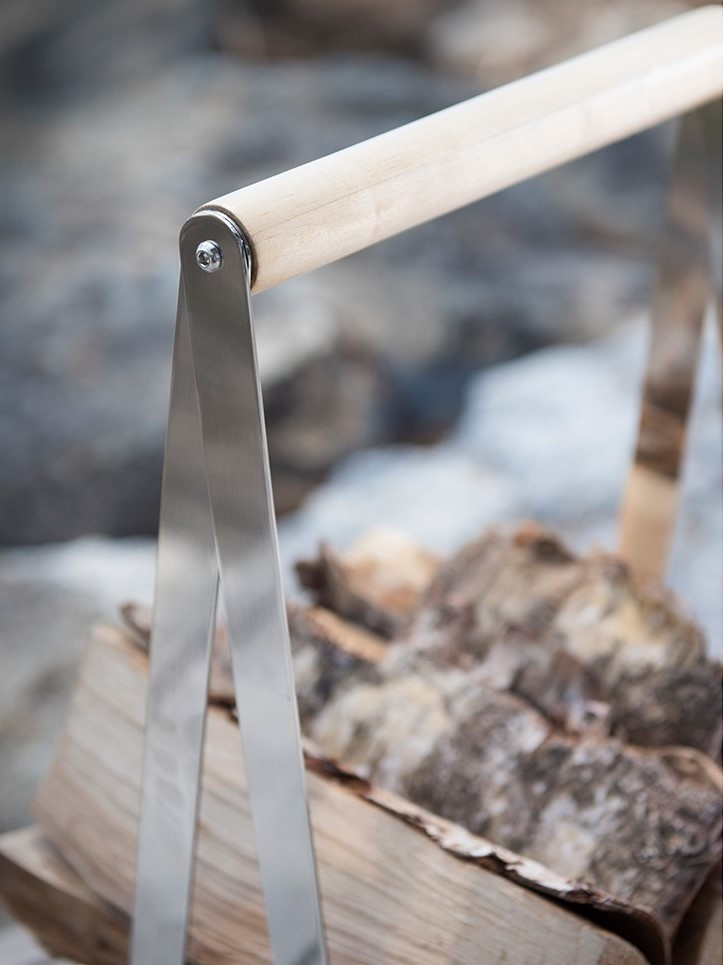 Närbild på vedkorgens handtag med ved i 