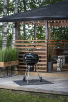 Kolgrill Gourmet 57 Grillen står på en uteplats