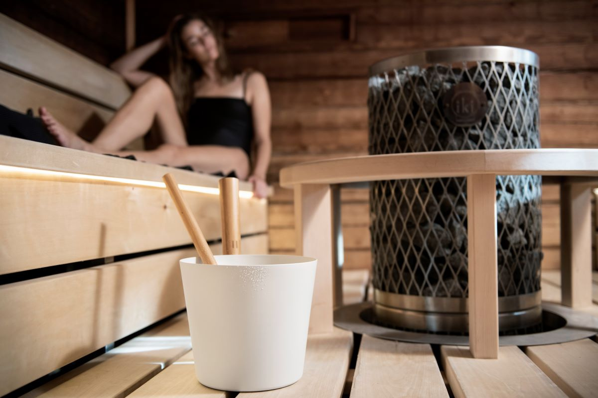 Hinken står i en bastu med en tjej i bakgrunden