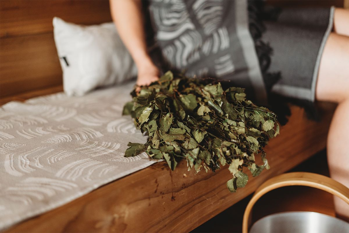 Närbild på basturuskan bredvid en person i en bastu