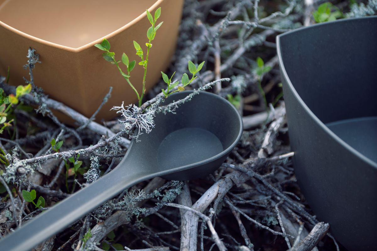 Bastuskopan bredvid två hinkar bland grenar