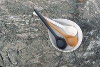 Bastuskopa i Svart Biokomposit Tre bastuskopor i en hink på en stenhäll