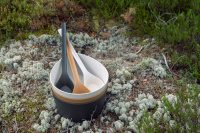 Bastuskopa i Svart Biokomposit Tre bastuskopor i en trave hinkar bland mossa